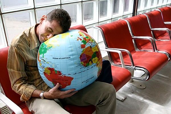 Precision-Nutrition-Blog-All-About-Jet-Lag-Airport-Sleeping-On-Globe-Ball